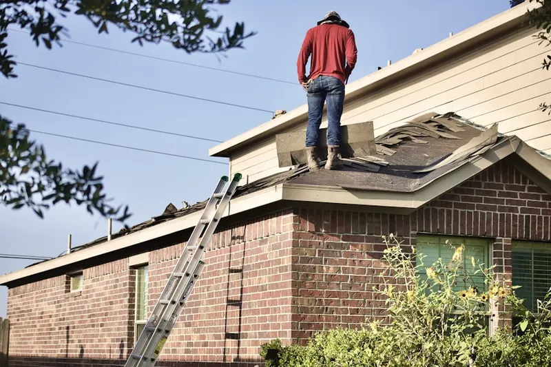 Professional roofer working on a residential roof in Fishers Island